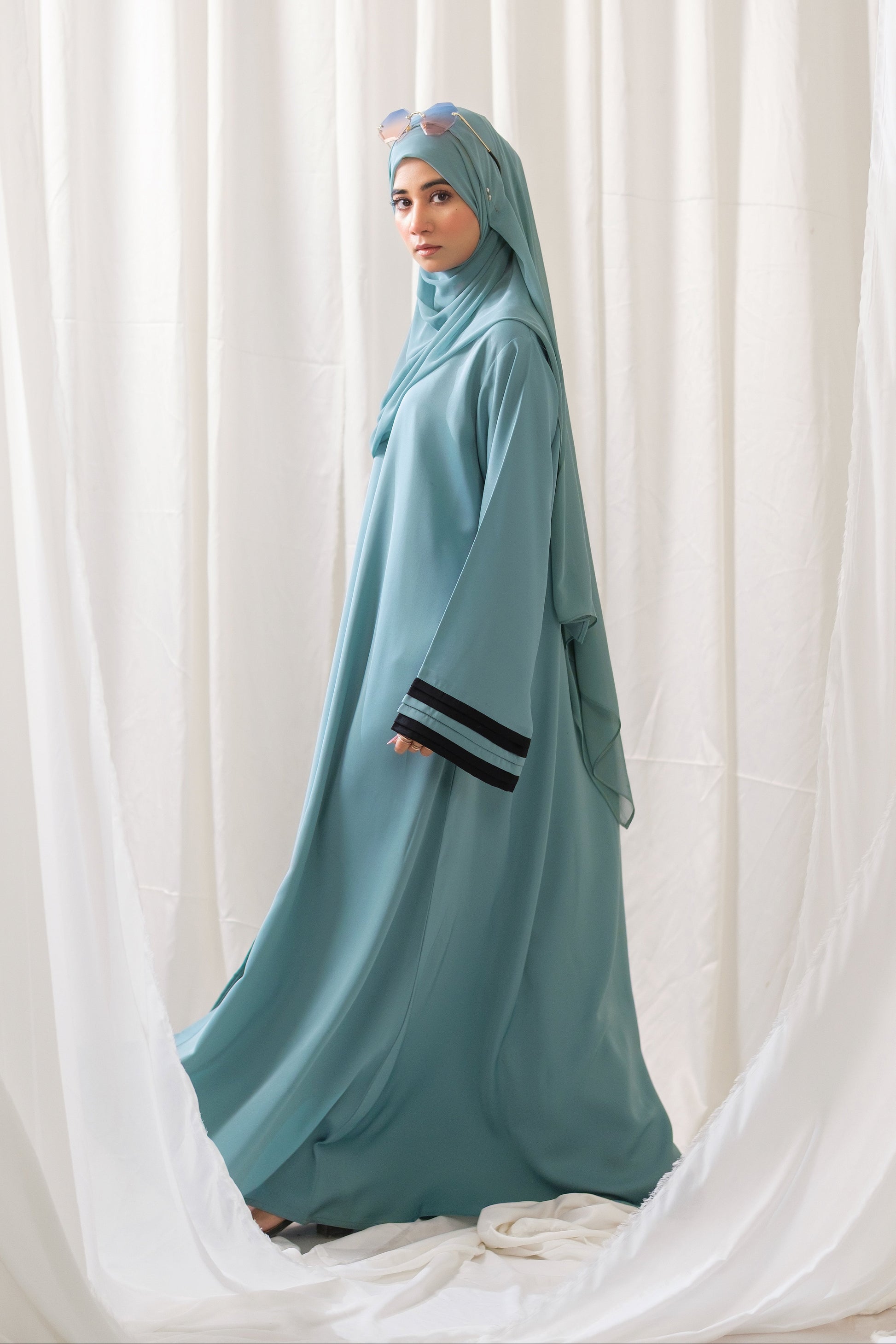 Dhaagey Aqua Serene Abaya in Imported Nidha Fabric with Black Contrast Trim, side full view.