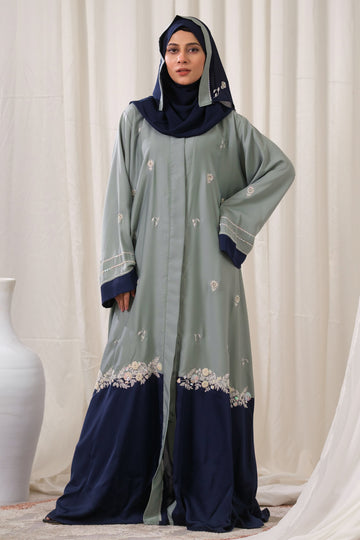 Dhaagey Artisan Weave Front-Open Abaya in Sage Green and Navy, showing scattered embroidery and dense floral border at the color block seam.