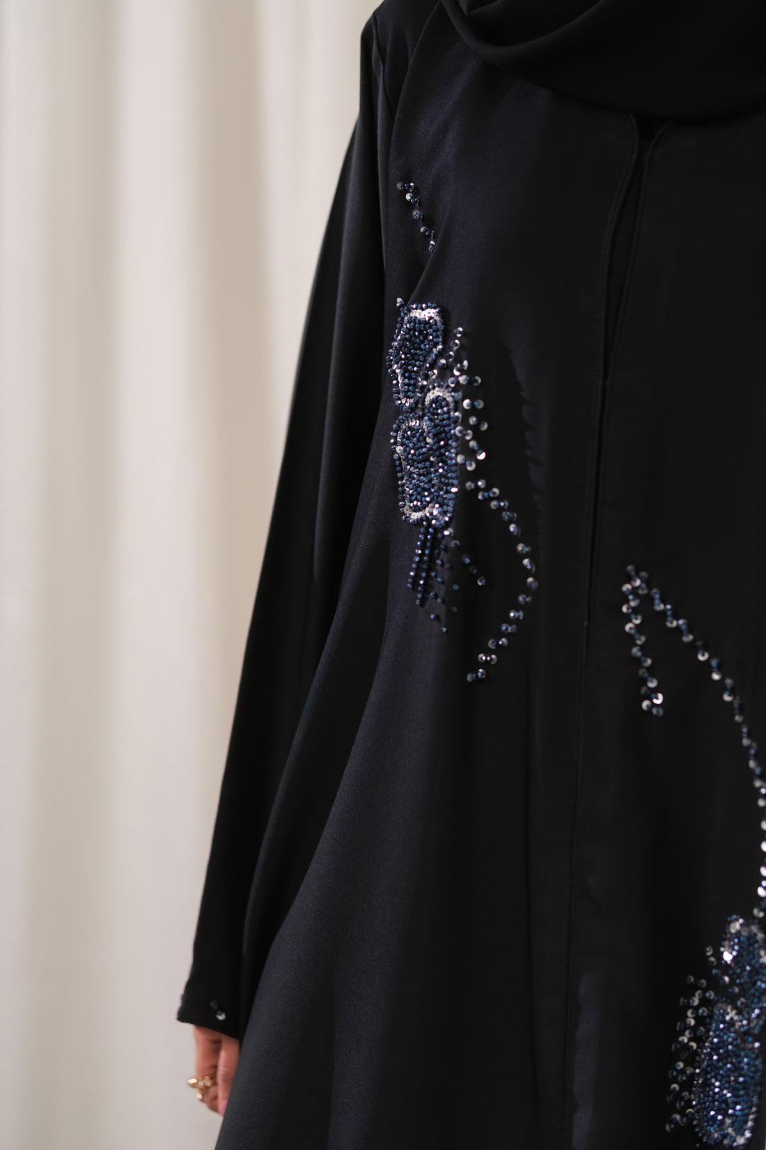 Dhaagey Cosmic Trail Front-Open Abaya in Black Nidha, showing vertical trail of blue and silver beaded floral design and matching Chiffon hijab.