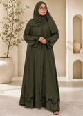 Full-length studio portrait of a model wearing the Olive Arcana abaya in premium imported olive green Nidha fabric, featuring a flowing silhouette, hand-beaded black glass scalloped trim on the hem and cuffs, scattered crystal accents, and a matching olive hijab in a luxury archway setting