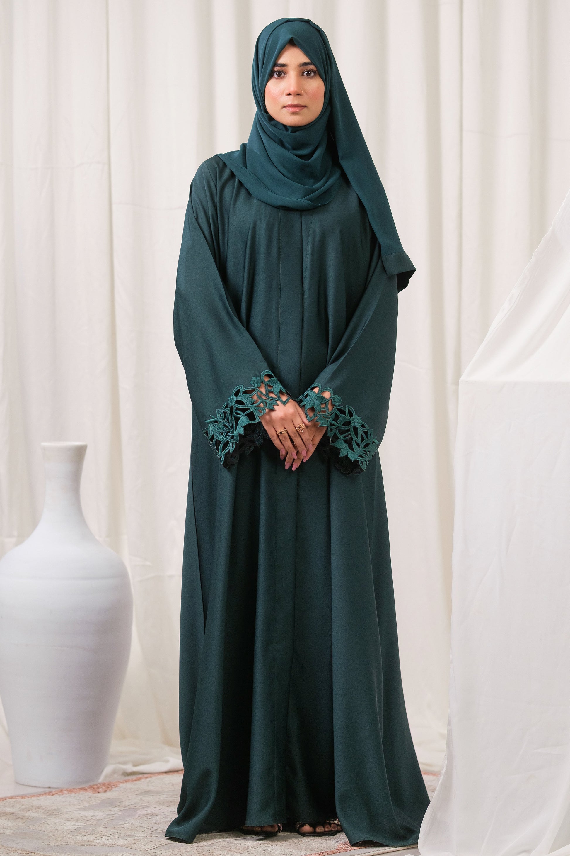 Dhaagey Emerald Cut Front-Open Abaya in Deep Emerald Nidha, showing floral cutwork cuffs and matching Chiffon hijab.