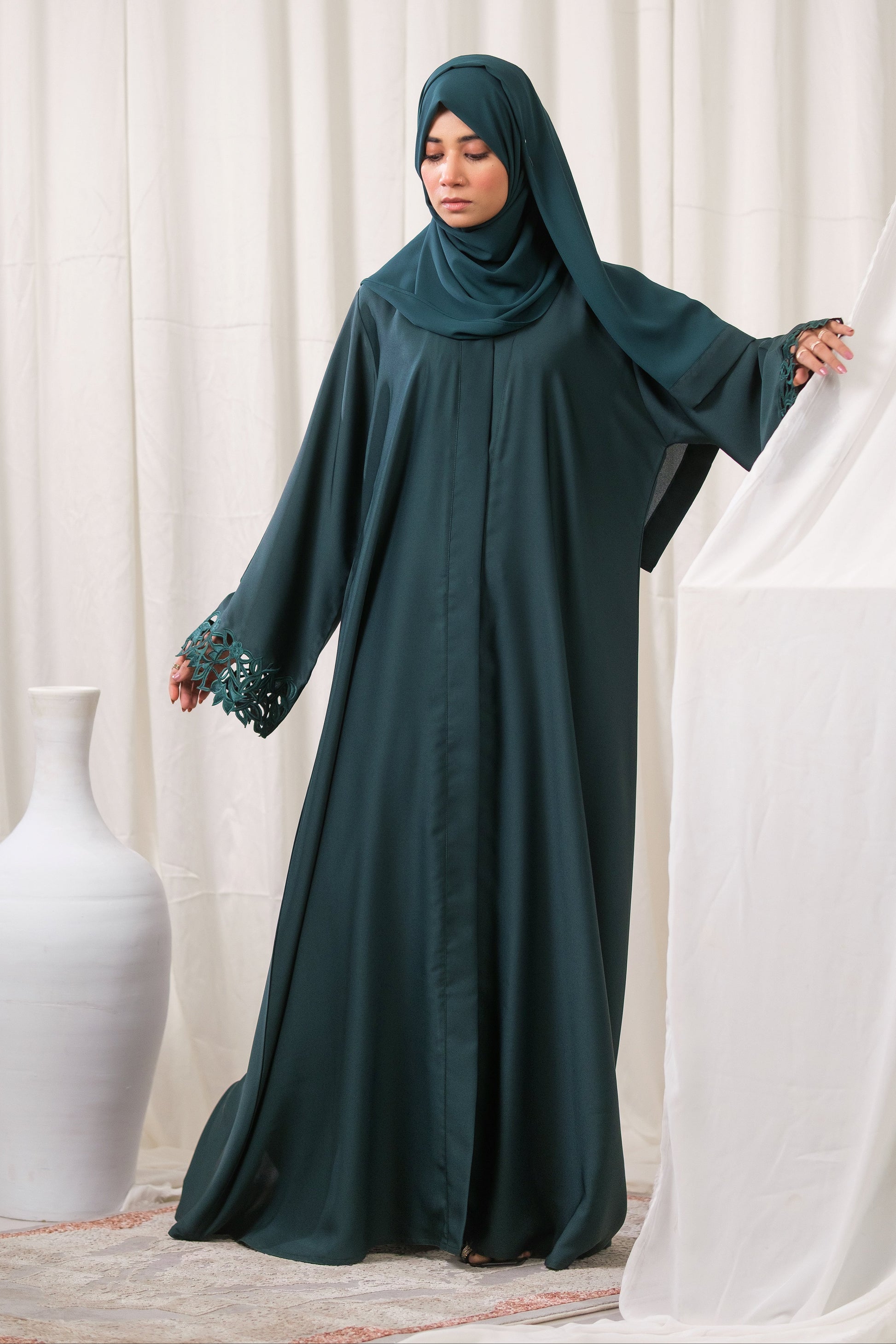 Dhaagey Emerald Cut Front-Open Abaya in Deep Emerald Nidha, showing floral cutwork cuffs and matching Chiffon hijab. Full