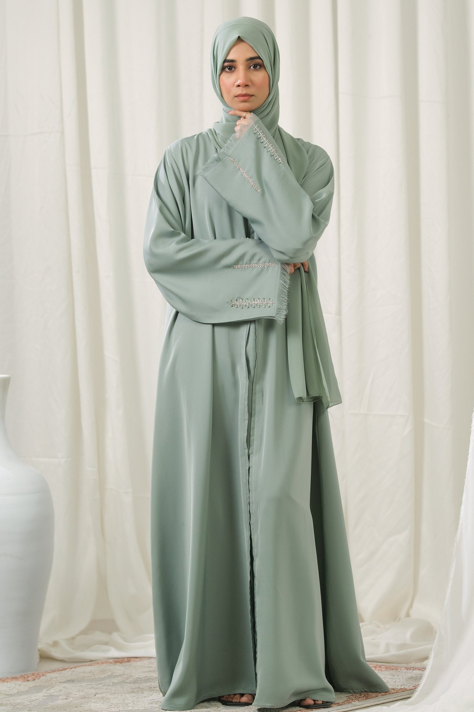 Dhaagey Mint Pleat Dusty Mint Front-Open Abaya in Imported Nidha, showing embroidered cuffs and matching Chiffon hijab.