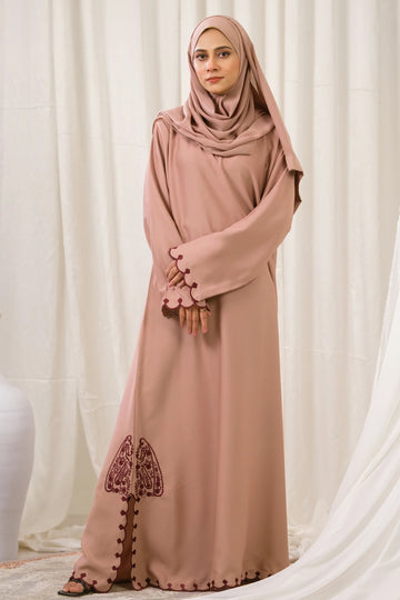 Dhaagey Petal Edge Front-Close Abaya in Nude Pink Nidha, showing asymmetrical maroon embroidery near the hem and scalloped trim.