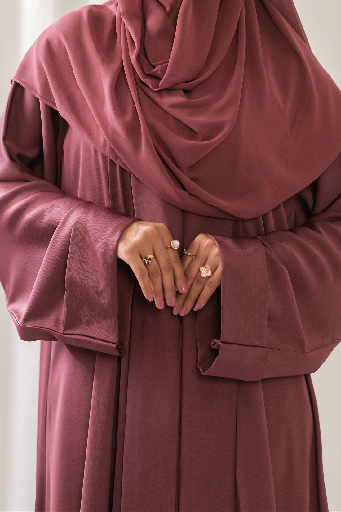Dhaagey Rosalie Pleat Front-Open Abaya in Dusty Rose Romantic Nidha, showing sharp vertical pleats on the front and cuffs, and matching Chiffon hijab.