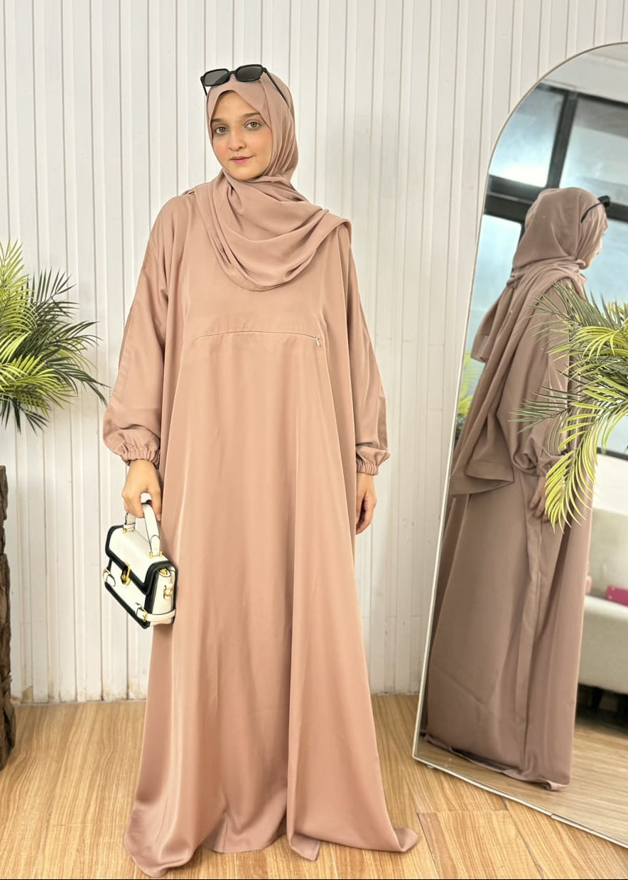 Muted latte taupe Farasha abaya with secure zipper pocket detail and black and white contrast purse.