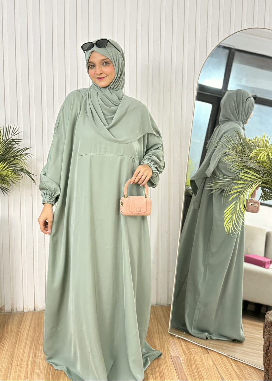 Sage green loose-fit travel abaya set with front zip pocket and blush pink mini bag