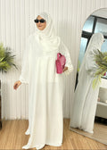 Modern white butterfly cut Nidha travel abaya with zippered front pocket, elastic sleeves, and hot pink handbag.